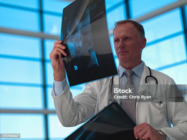 Doctor Reviewing Xrays Stock Photo - Download Image Now - X-ray Image, 45-49 Years, Adult