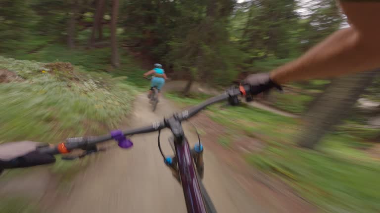 Mountain biker descends mountain trail in the forest