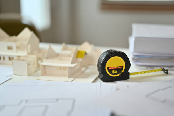 istock A measuring tape, architectural model and blueprints on desk. Building, construction and architect concept 1707524690