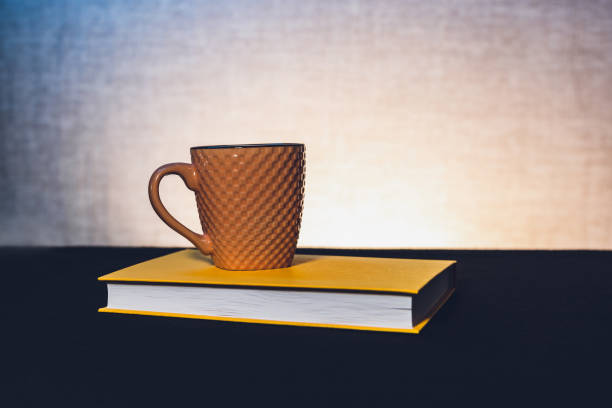 istock Mug with a book the theme of learning or creating a postcard 1707540044