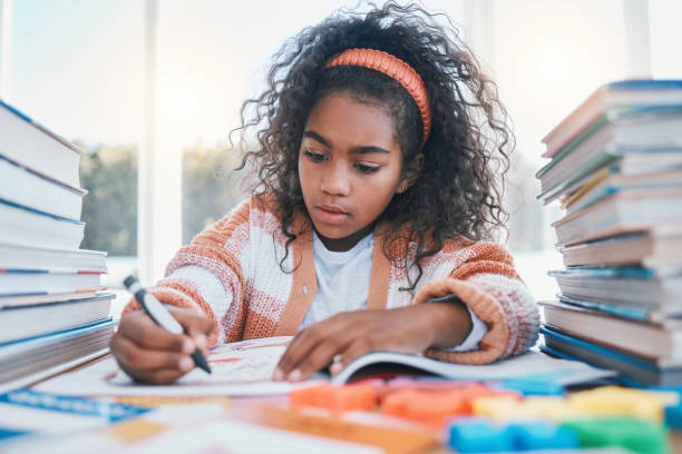 istock Education, creative and child coloring in a book for artistic project, assignment or assessment. Crayon, hobby and girl kid student writing for learning in a notebook for homework by a desk at home. 1707550965