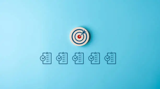 Photo of Target objective with work checklist for business objective target goal concept. Aiming dart board with check board icons. Standards with Quality Assurance improvement. Standardization, certification.