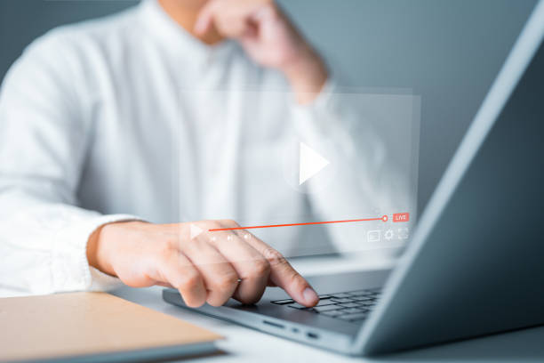 istock Online live streaming video. Businessman watches real-time content on computer laptop, a seamless internet connection. Live broadcast and playing content in cloud server technology, Online learning. 1707567466