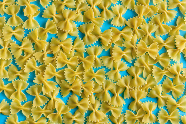 istock Raw pasta farfalle with copy space on blue background 1707574560