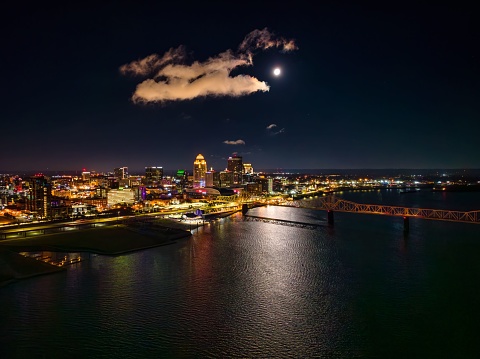 An aerial shot of a full moon over Louisville, Kentucky, and the Ohio River at night.