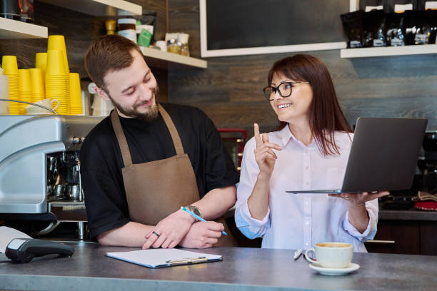 istock Team male and woman talking, working, using laptop, coffee shop 1707607422