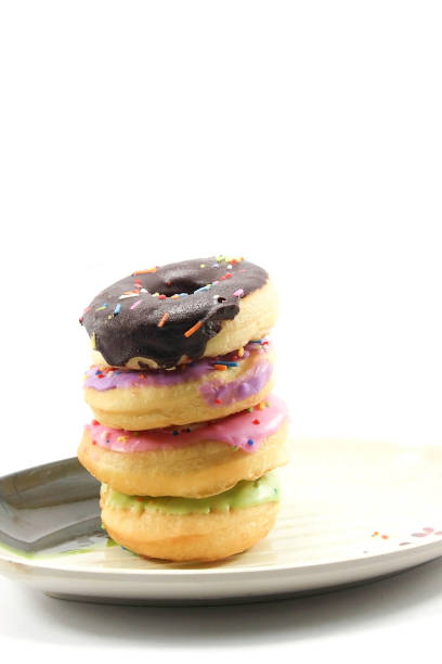 Donut Set: There is a pink green chocolate with a multi colored chocolate glaze on the donut. On a white background