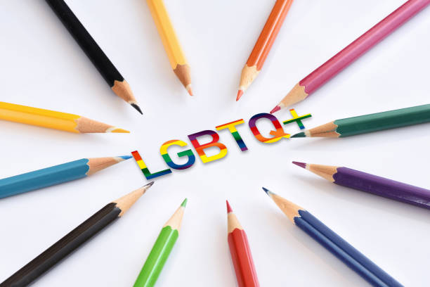 LGBTQ+ written on blue puzzle with coloured pencils isolated on white background stock photo