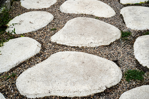 Image of a garden path pavement made of large cement blocks and pebbles.