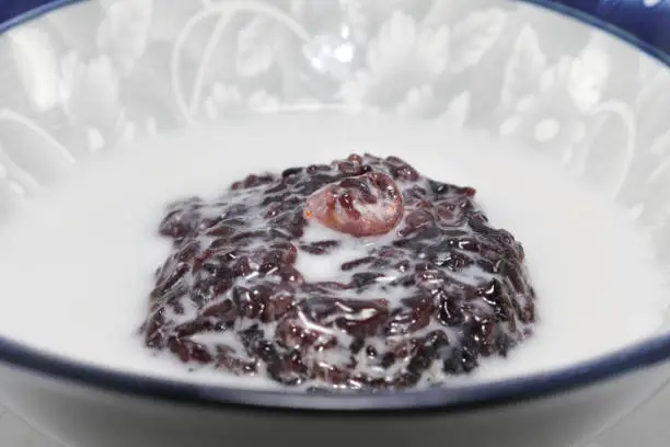 Photo of Traditional Thai desserts, black glutinous rice, coconut milk, delicious taste, sweet and creamy in a seramic bowl