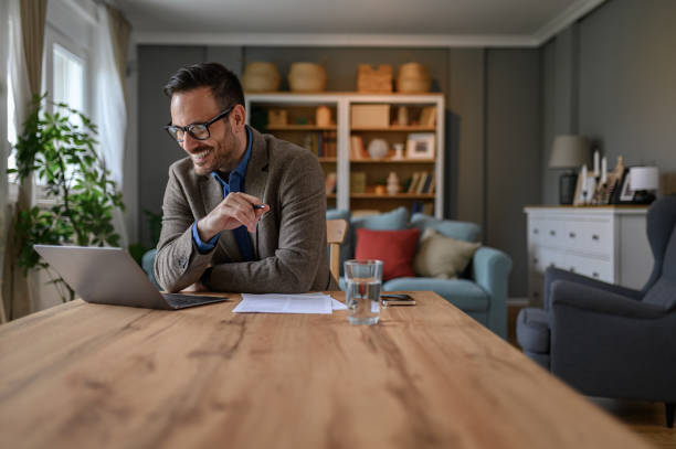 istock Smiling male professional discussing business ideas over video call on wireless computer at home 1707648780