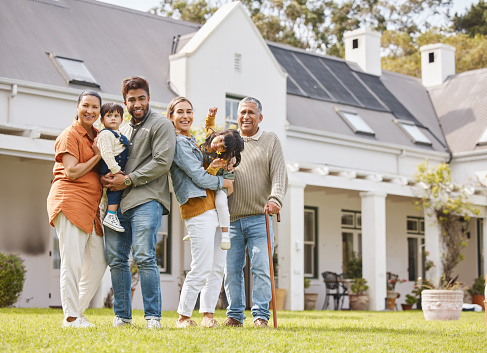 Happy big family, real estate and new home on grass or lawn together in happiness for property or investment. Portrait of parents, grandparents and kids hug for house, moving in or outdoor mortgage