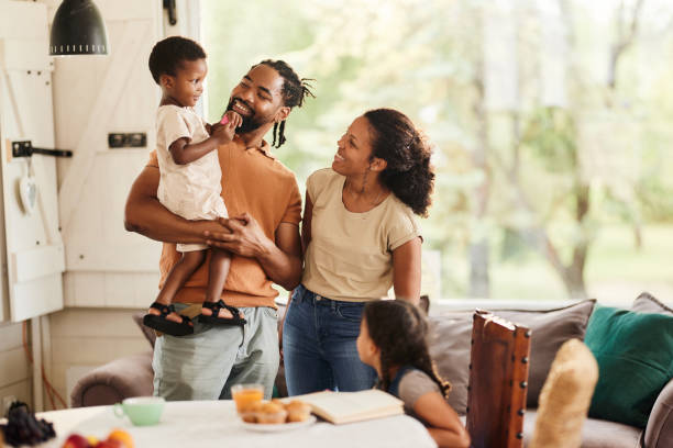 Happy black family talking while enjoying at home.