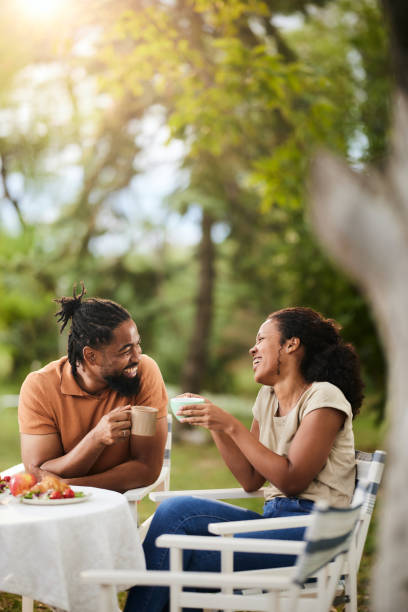 istock Happy black couple toasting with cups during a meal in the backyard. 1707678317
