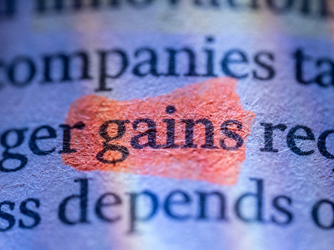 Gains word, written in a financial newspaper. Colors produced by color filters in flashes