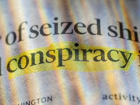 Conspiracy word, written in a financial newspaper. Colors produced by color filters in flashes