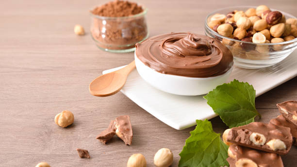 istock Chocolate cream and hazelnuts in containers on wooden table 1707719308