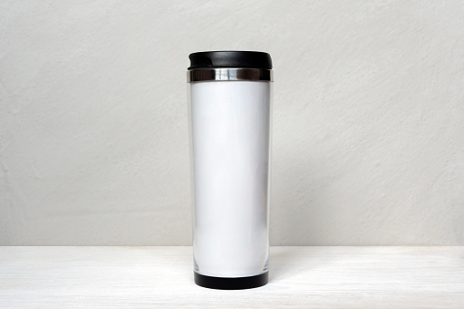 White thermo tumbler mockup on white gray background. Cup for design