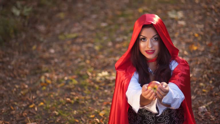 Little Red Riding Hood Offering An Apple In The Forest