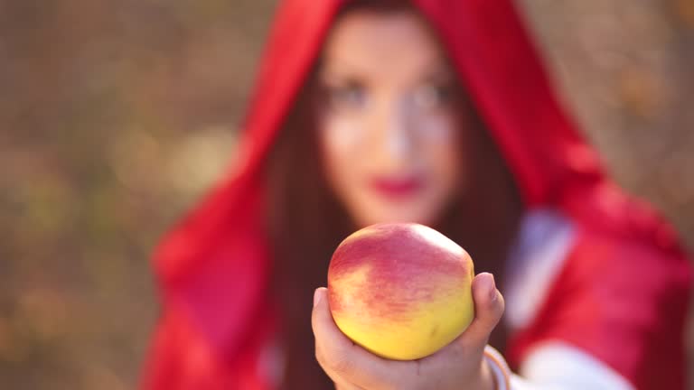 Little Red Riding Hood Offering An Apple In The Forest