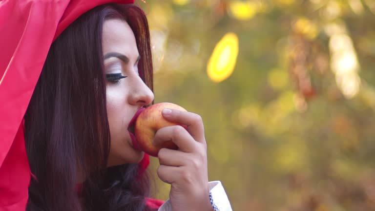 Little Red Riding Hood Eating An Apple In The Forest