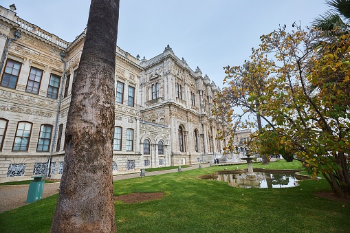Istanbul, Turkey - November 23, 2021: The famous Dolmabahce Palace. The facade of the building and a pond in the garden.