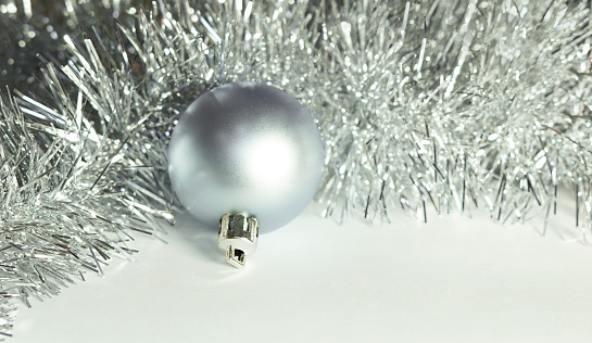 White and silver metal textured Christmas balls on dark gray background. Twisted striped Christmas ornaments. Christmas decoration, festive atmosphere concept. Black and white.