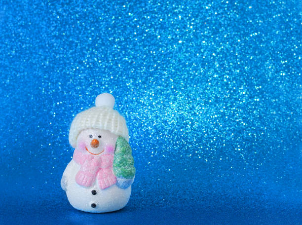 istock snowman with christmas tree on blue  background. Copy space 1707799765