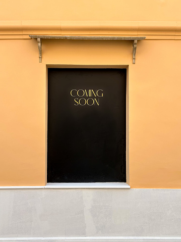 Covered window with black background and written text “Coming soon”