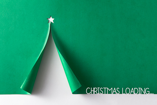 Christmas tree created with curled paper with text on green background
