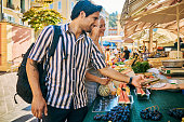 Adult couple shopping at a local Provencal market in the south of France while on vacation
