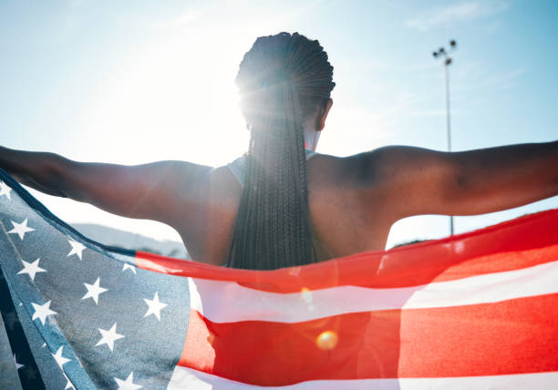 atleta, bandiera americana e sport con una donna all'aperto in uno stadio per celebrare il paese, l'orgoglio e la vittoria. schiena di una persona per lo sport olimpico, il fitness e l'esercizio fisico alla competizione negli stati uniti - oplympics foto e immagini stock