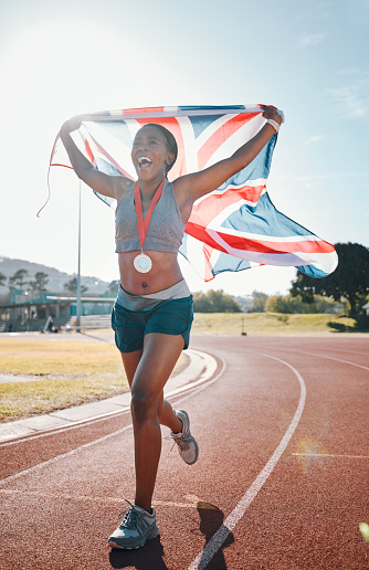 Runner, achievement and black woman with celebration, UK flag and sports with competition, pride and winner. African person, happy athlete or champion with British symbol, pride and medal for winning