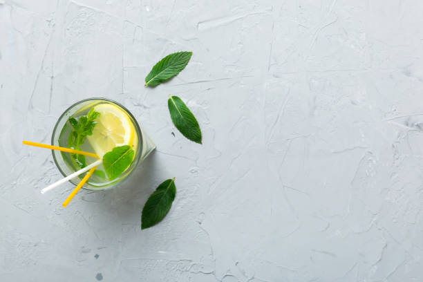 Caipirinha, Mojito cocktail, vodka or soda drink with lime, mint and straw on table background. Refreshing beverage with mint and lime in glass top view flat lay Caipirinha, Mojito cocktail, vodka or soda drink with lime, mint and straw on table background. Refreshing beverage with mint and lime in glass top view flat lay. vodka soda top view stock pictures, royalty-free photos & images