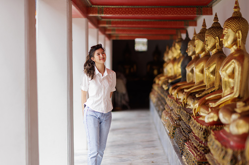 Asian woman walk around and look buddha statue  at Wat Pho temple in Bangkok Thailand