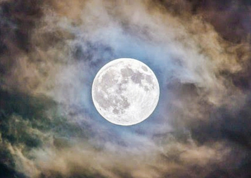 Full moon in the cloudy sky