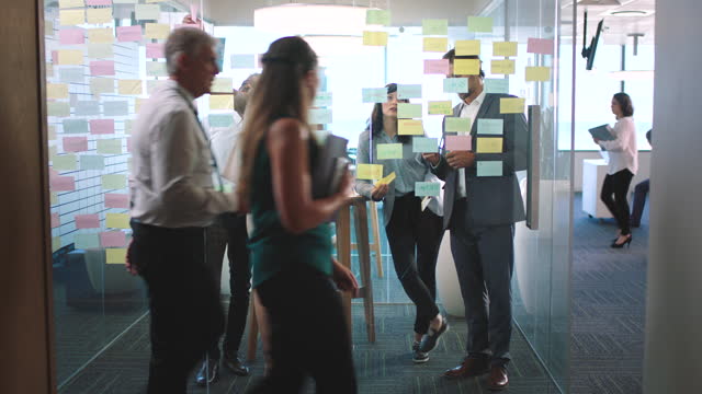 Teamwork collaboration, sticky note planning and window solution for ideas, vision and collaboration in modern office agency. Diversity business people thinking, working and innovation strategy notes