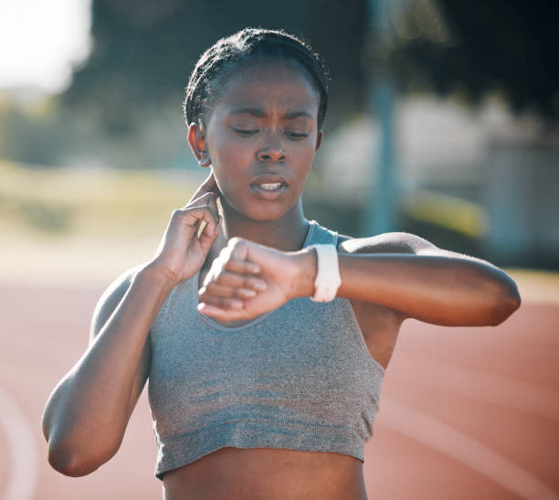 istock Time, pulse and exercise with a woman outdoor on a track for running, training or workout. African athlete person at stadium for goals, fitness and body wellness with a watch for progress or steps 1707844222