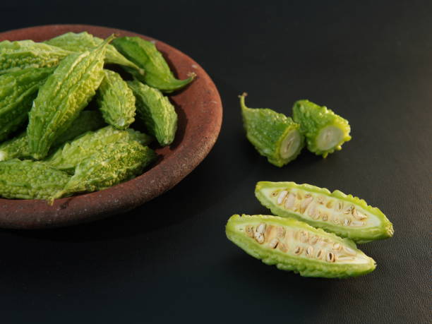 istock Momordica charantia fruit or (Peria, Bitter Gourd, Bitter Melon, Bitter Cucumber, Balsam Pear, Leprosy Gourd, Pare) on a plate on black background 1707858563