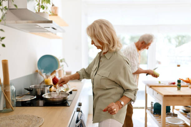 istock Senior woman cooking something while her husband is helping her 1707900205