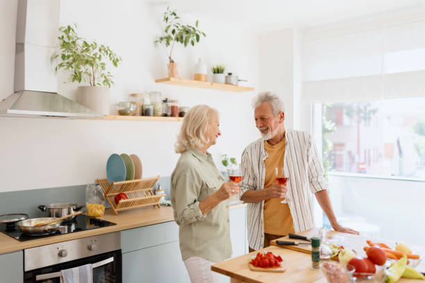 istock Senior man and woman drinking wine while preparing a lunch 1707903028
