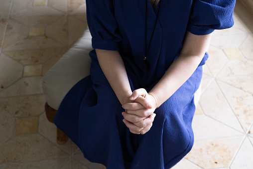 A woman anxiously folds her hands.
A woman praying with folded hands. Prayer.
Taken from above. Overhead view.