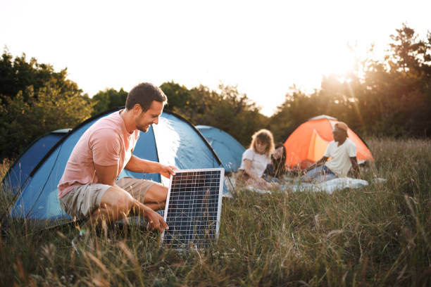istock Young man setting up solar panel near camping spot in nature 1707929185