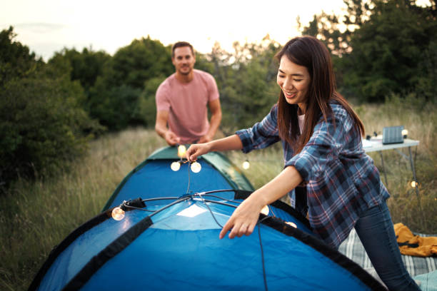 istock Couple decorating camping tents with string lights 1707930891