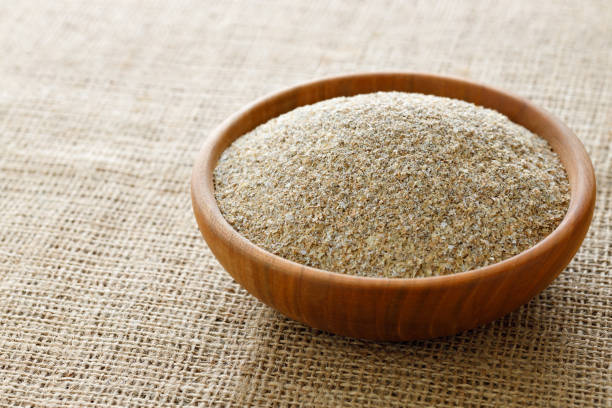 wheat bran in bowl on table with sackcloth stock photo