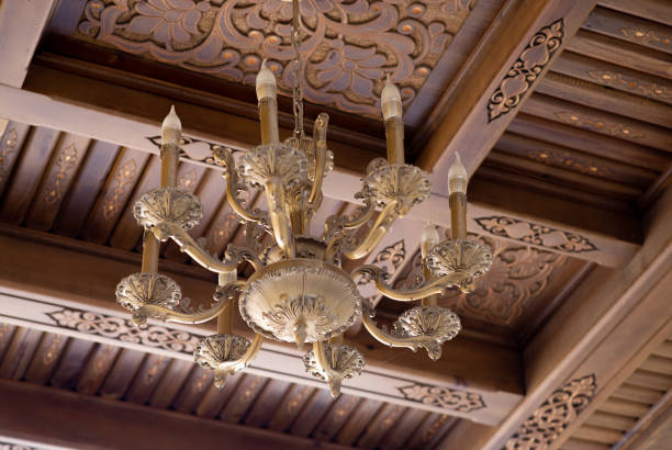 Ancient chandelier on wooden carving ceiling background