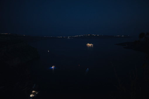Cruise ships at night sailing thru the bay of Santorini, Greek Islands