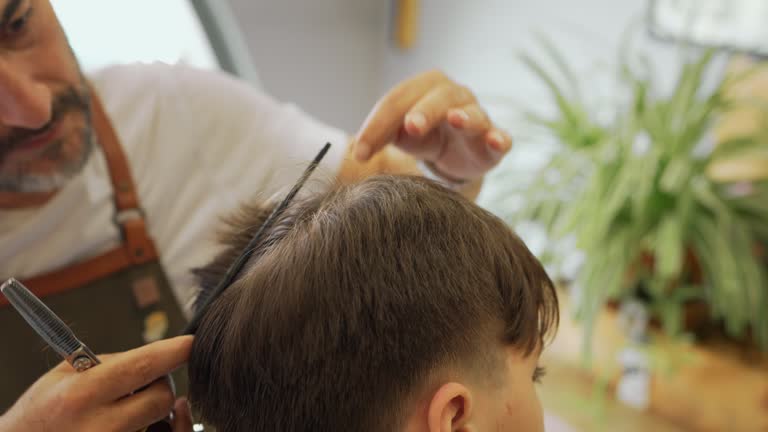 Teenage boy is having a haircut at the Barber Shop