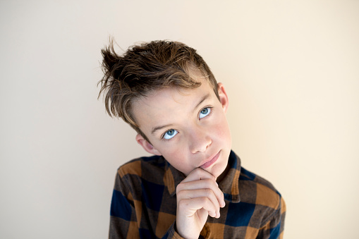 portrait of cool, young boy in front of brown background