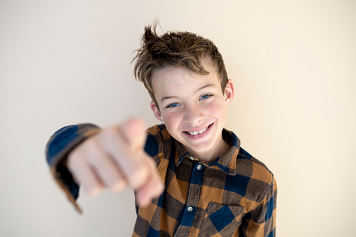 portrait of cool, young boy in front of brown background